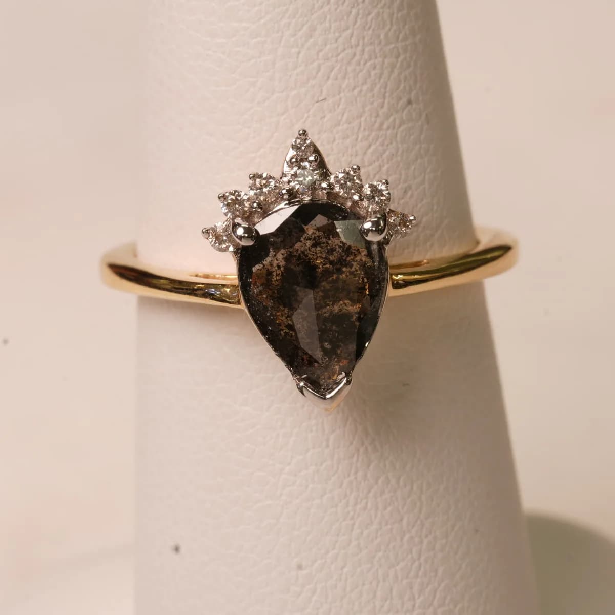 The pear diamond ring on a white display cone, straight off the camera on shoot day.